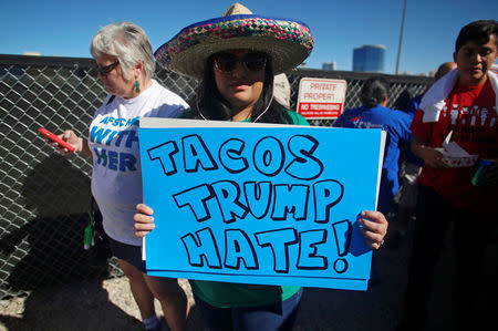 A protestor holds a sign at the Wall of Tacos demonstration in front of the Trump International Hotel Las Vegas before the last 2016 U.S. presidential debate in Las Vegas, Nevada, U.S., October 19, 2016. REUTERS/Jim Urquhart