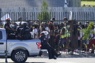 Police officers watch as protesters march past the Churchill Downs racetrack before the 146th running of the Kentucky Derby, Saturday, Sept. 5, 2020, in Louisville, Ky. (AP Photo/Charlie Riedel)