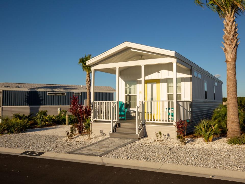 Two cabana cabins with palm trees.