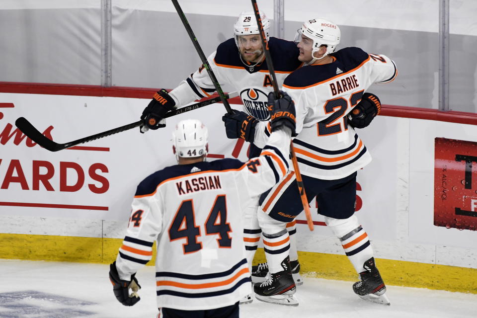 Edmonton Oilers' Leon Draisaitl (29) celebrates his first goal with Zack Kassian (44) and Darnell Nurse (25) during the first period of an NHL game against the Winnipeg Jets, in Winnipeg, Manitoba on Sunday, May 23, 2021. (Fred Greenslade/The Canadian Press via AP)
