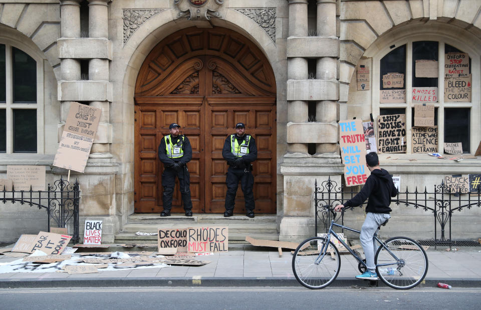 Police during a protest calling for the removal of the statue of 19th century imperialist, politician Cecil Rhodes from an Oxford college which has reignited amid anti-racism demonstrations.