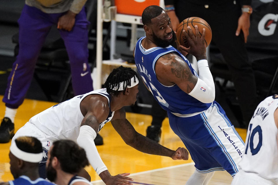Los Angeles Lakers forward LeBron James, right, tries to move by Minnesota Timberwolves forward Jarred Vanderbilt during the first half of an NBA basketball game Tuesday, March 16, 2021, in Los Angeles. (AP Photo/Mark J. Terrill)