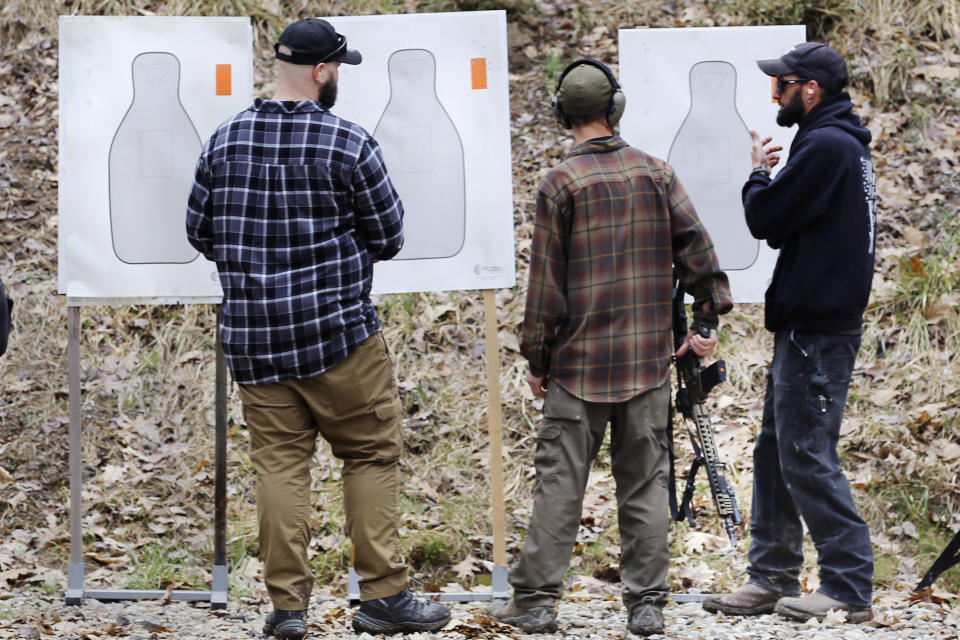 People look at targets during a pause in a shooting session at Slate Ridge, an unpermitted gun range and firearms training center, Saturday April 17, 2021, in West Pawlet, Vt. A judge has again issued an arrest warrant, Monday, Dec. 4, 2023, for Daniel Banyai, the owner of the former firearms training center in Vermont, ruling that he is in contempt of court for failing to bring his property into compliance after an inspection last week. Monday's ruling orders him to turn himself in by Dec. 22. (AP Photo/Wilson Ring, File)