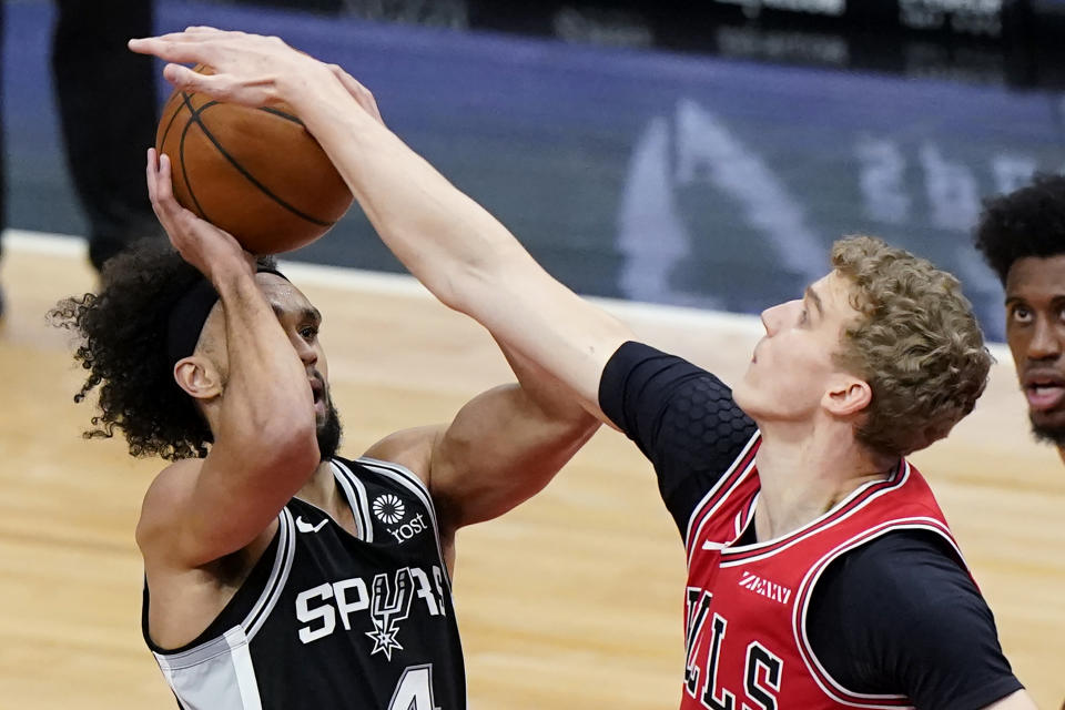 San Antonio Spurs guard Derrick White, left, shoots against Chicago Bulls forward Lauri Markkanen during the first half of an NBA basketball game in Chicago, Wednesday, March 17, 2021. (AP Photo/Nam Y. Huh)