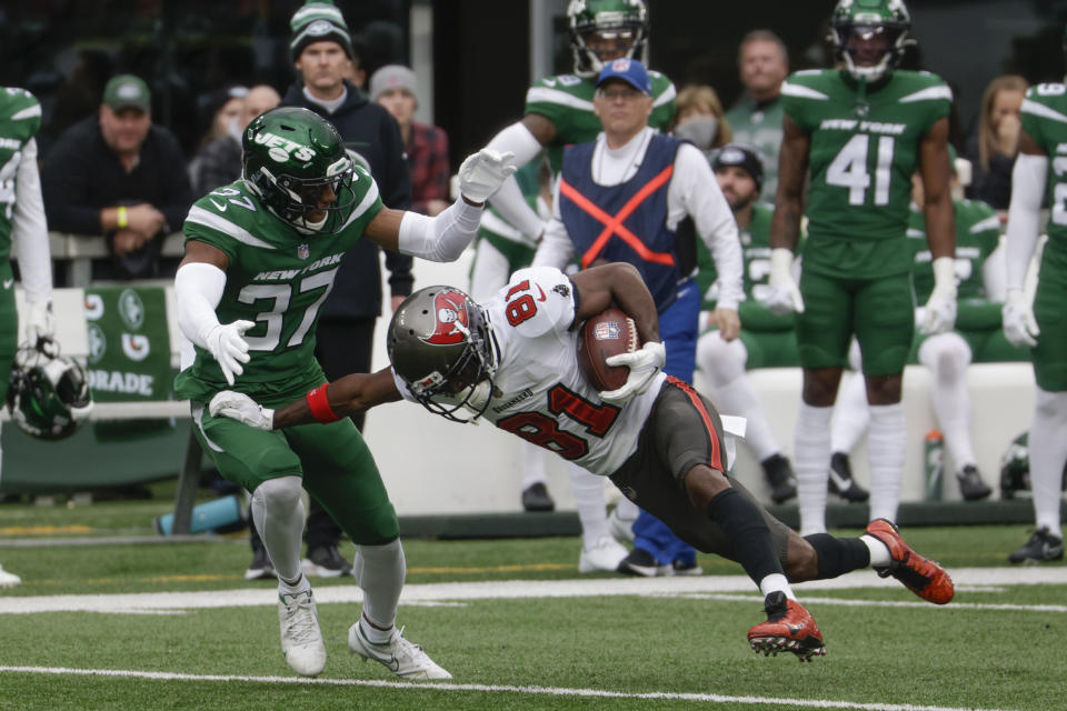 New York Jets' Bryce Hall, left, tackles Tampa Bay Buccaneers' Antonio Brown during the first half of an NFL football game, Sunday, Jan. 2, 2022, in East Rutherford, N.J. (AP Photo/Corey Sipkin)