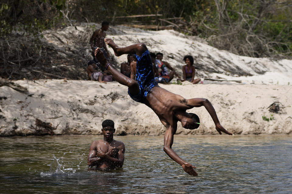 Members of the Kalunga quilombo, the descendants of runaway slaves, bathe in Rio Branco, during the culmination of the week-long pilgrimage and celebration for the patron saint "Nossa Senhora da Abadia" or Our Lady of Abadia, in the rural area of Cavalcante in Goias state, Brazil, Saturday, Aug. 13, 2022. (AP Photo/Eraldo Peres)