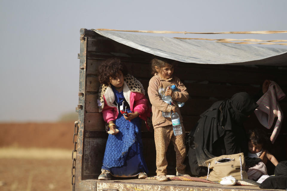 Iraqi refugees ride a pick-up truck in al-Kherbeh village