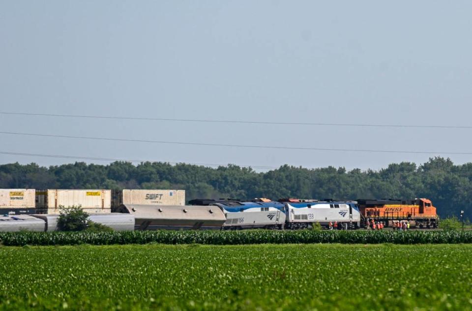 One day after a train crash left three people dead and scores injured, a freight train passed as investigators combed the scene of the Amtrak train derailment on Tuesday, June 28, 2022, in Mendon, Missouri. The train traveling from Los Angeles to Chicago on Monday when it hit a dump truck and derailed.