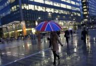 Workers walk in the rain at the Canary Wharf business district in London November 11, 2013. REUTERS/Eddie Keogh