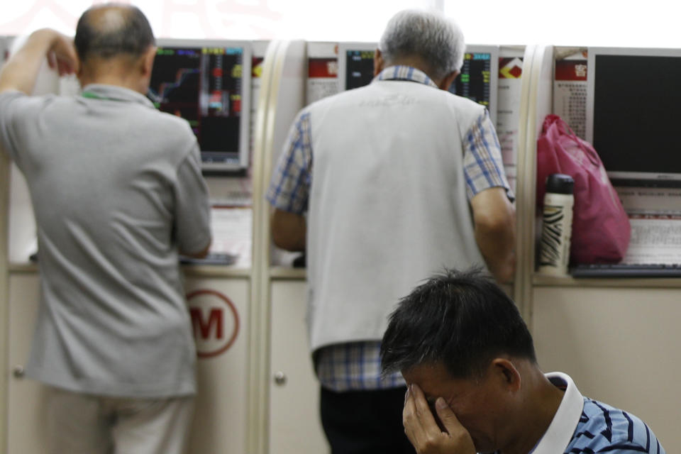 A man reacts as investor check their stock prices at a brokerage house in Beijing, Wednesday, May 22, 2019. Shares edged in Asia on Wednesday after a rebound in technology stocks helped power an overnight rally on Wall Street. (AP Photo/Andy Wong)