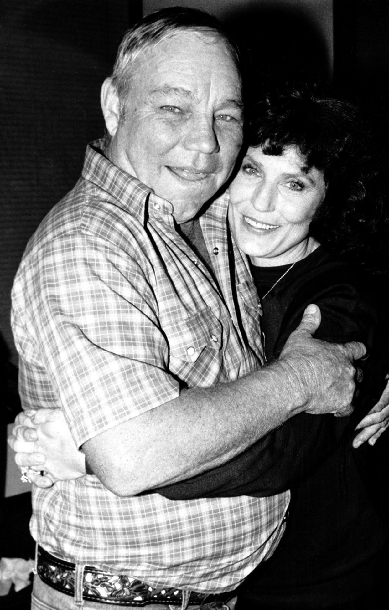 FILE - Country music singer Loretta Lynn embraces her husband, Oliver "Mooney" Lynn, during rehearsal for her New York debut, on Oct. 21, 1982. Lynn, the Kentucky coal miner’s daughter who became a pillar of country music, died Tuesday at her home in Hurricane Mills, Tenn. She was 90. (AP Photo/Antonio Carozza, File)