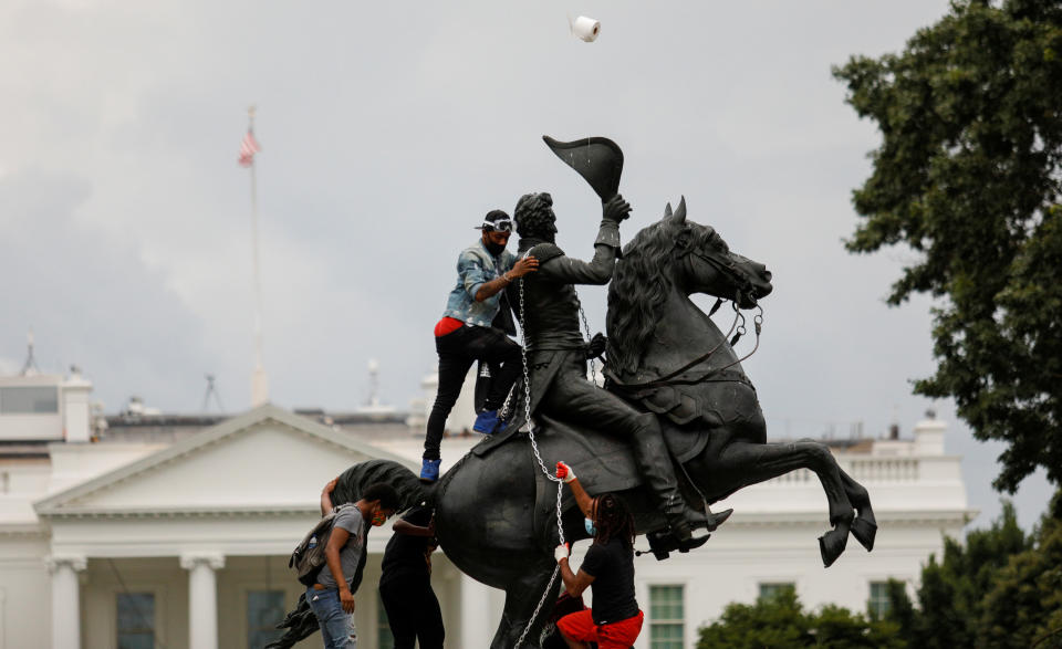 Protestors attach a chain to the statue of U.S. President Andrew Jackson in the middle of Lafayette Park in front of the White House in an attempt to pull it down as someone throws a roll of toilet paper at the statue during racial inequality protests in Washington, D.C., U.S., June 22, 2020. REUTERS/Tom Brenner     TPX IMAGES OF THE DAY