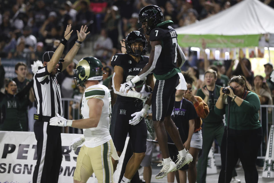 Hawaii wide receiver Steven McBride (7 celebrates with tight end Devon Tauaefa (87) after Tauaefa scored a touchdown against Colorado State during the first half of an NCAA college football game Saturday, Nov. 25, 2023, in Honolulu. (AP Photo/Marco Garcia)