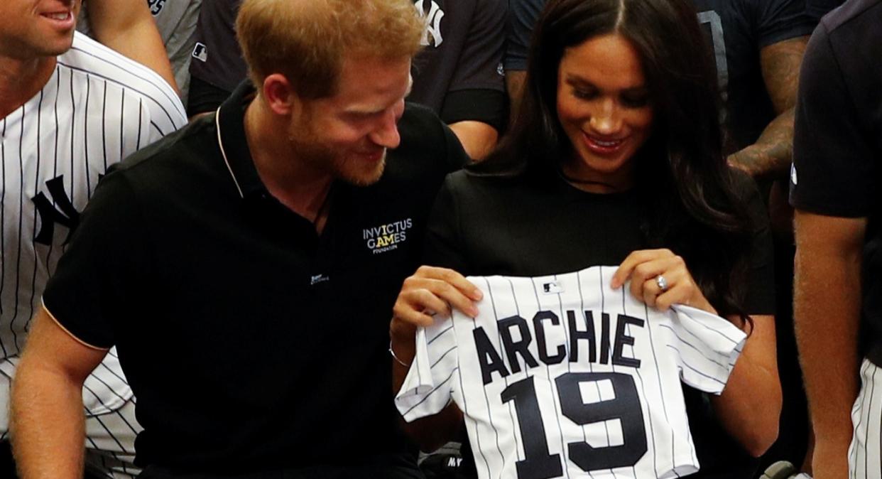 Meghan Markle and Prince Harry receive a New York Yankees team shirt for baby Archie at baseball game [Image: Getty]