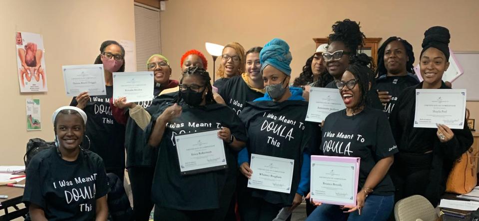 Doula students hold up their certificates after their skills assessment at doula Kay'La Mumford's doula training program.