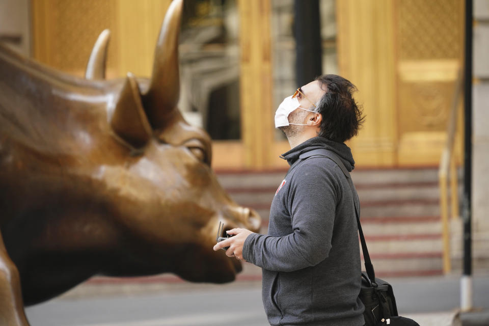 Un ciudadano junto a la estatua del toro situada muy cerca de Wall Street, donde se encuentra la Bolsa de Nueva York, y símbolo de la fortaleza de la economía estadounidense. John Nacion/STAR MAX/IPx 2020