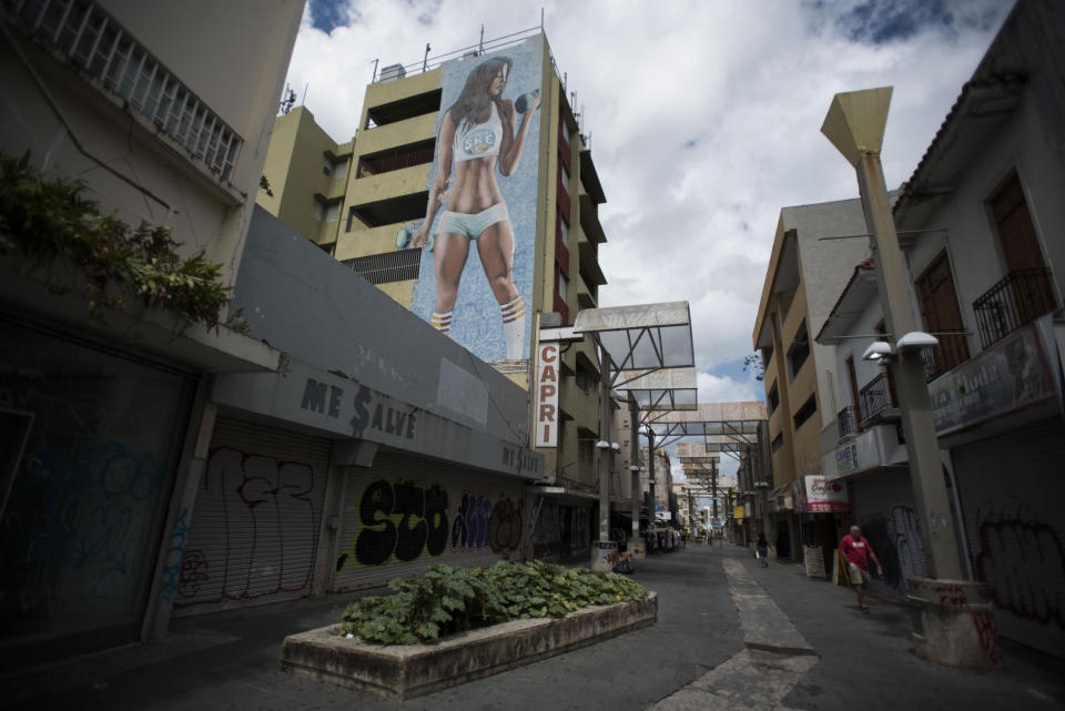 Shops are shuttered in the Paseo de Diego in San Juan, Puerto Rico, Wednesday, April 17, 2019. This central thoroughfare in Rio Piedras was filled years ago with stores that are closed and empty today. (AP Photo/Carlos Giusti)