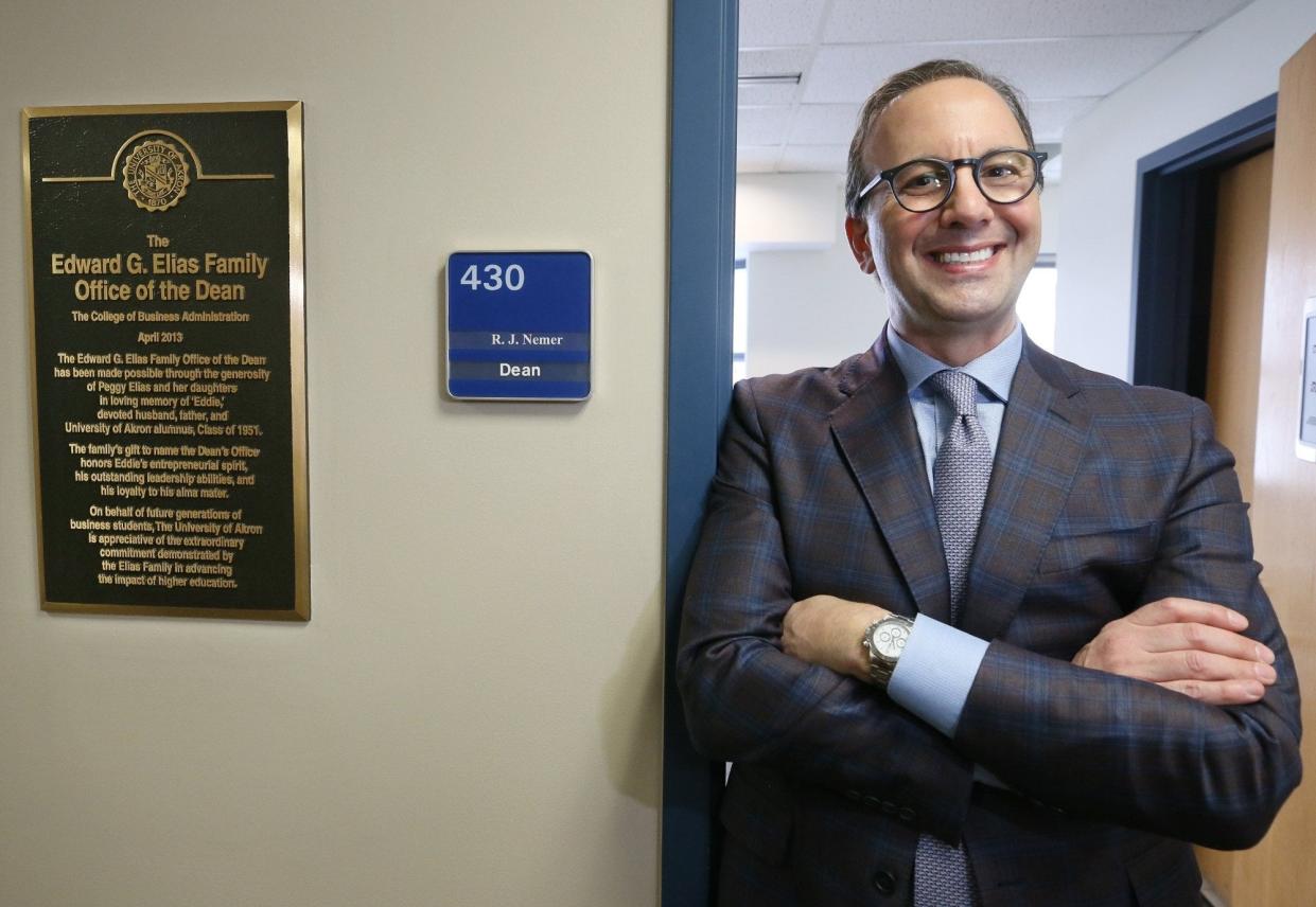 R.J. Nemer, dean of the College of Business at The University of Akron, poses in the doorway of his office next to a plaque naming it the Edward G. Elias Family Office of the Dean.