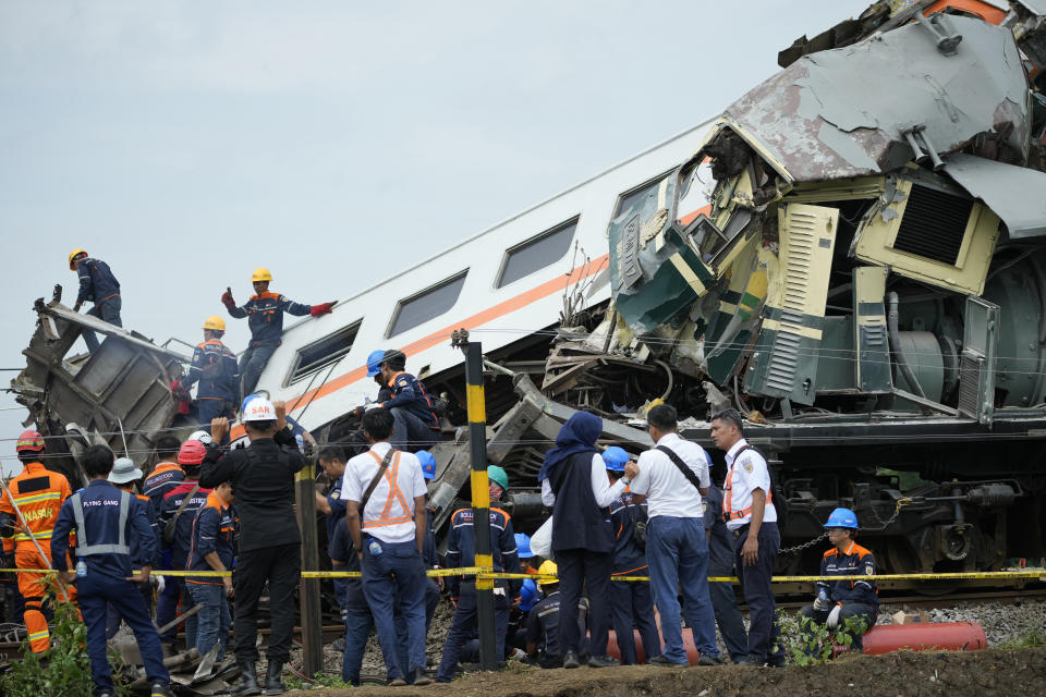 Rescuers inspect the wreckage after a collision between two trains in Cicalengka, West Java, Indonesia, Friday, Jan. 5, 2024. The trains collided on Indonesia's main island of Java on Friday, causing several carriages to buckle and overturn, officials said. (AP Photo/Achmad Ibrahim)