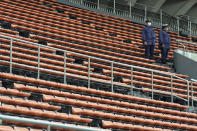 Police officers stand guard at empty seats of the grandstand during the unveiling ceremony for Olympic Flame of the Tokyo 2020 Olympic torch relay at Komazawa Olympic Park, Friday, July 9, 2021, in Tokyo. Komazawa Olympic Park, where the flame unveiling ceremony took place, was used as one of the venues during the previous Tokyo Olympics held in 1964.(AP Photo/Eugene Hoshiko)