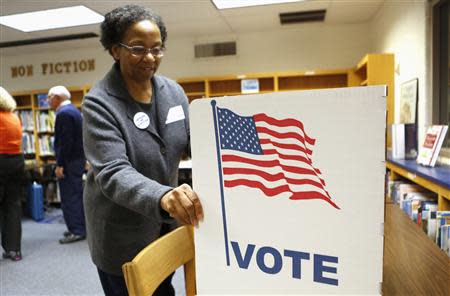 An election worker sets up a voting booth in the library of Spring Hill Elementary School, which is being used as a polling station in McLean, Virginia November 5, 2013. REUTERS/Kevin Lamarque