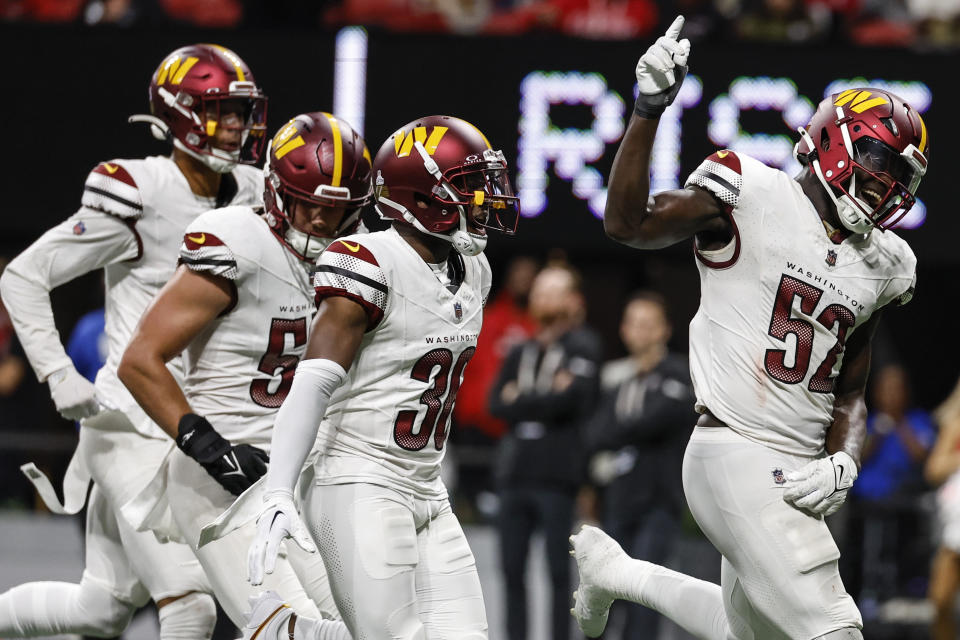 Washington Commanders linebacker Jamin Davis (52) runs toward the bench after a late-game interception against the Atlanta Falcons during the second half of an NFL football game, Sunday, Oct. 15, 2023, in Atlanta. Washington Commanders won 24-16. (AP Photo/Butch Dill)