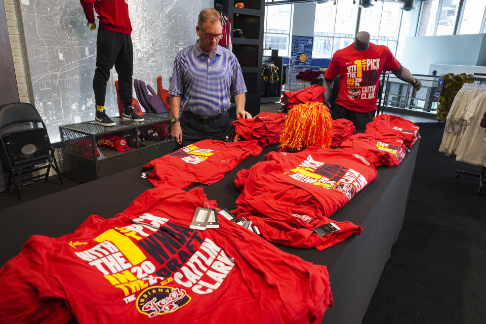 A customer looks over Caitlin Clark merchandise in the Indiana Fever team store in Indianapolis, Tuesday, April 16, 2024. The Fever selected Clark Clark as the No. 1 overall pick in the WNBA basketball draft. (AP Photo/Michael Conroy)