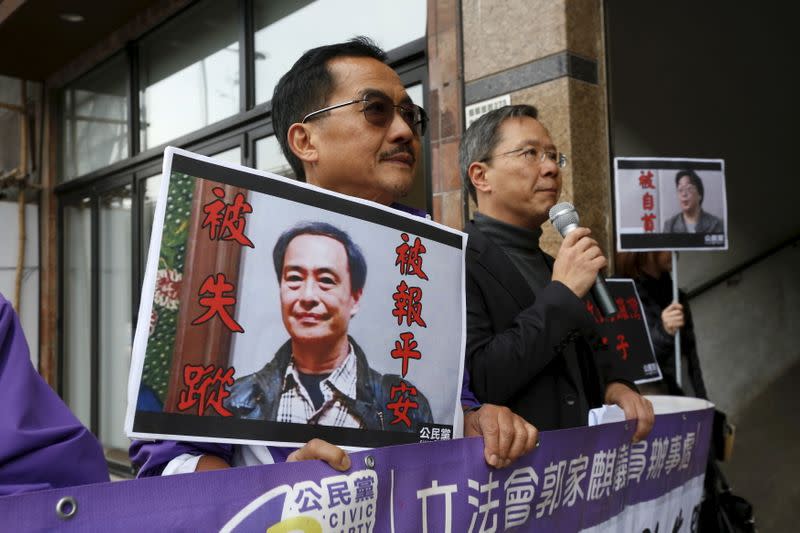 Members from the pro-democracy Civic Party carry a portrait of Lee Bo and Gui Minhai before they protest outside Chinese Liaison Office in Hong Kong