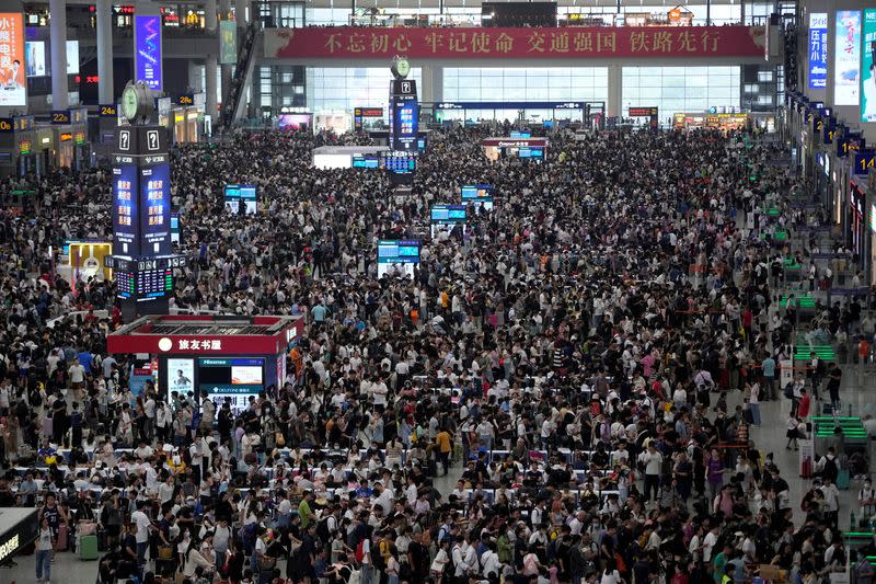 FILE PHOTO: People wait to board trains at the Shanghai Hongqiao railway station ahead of the National Day holiday, in Shanghai
