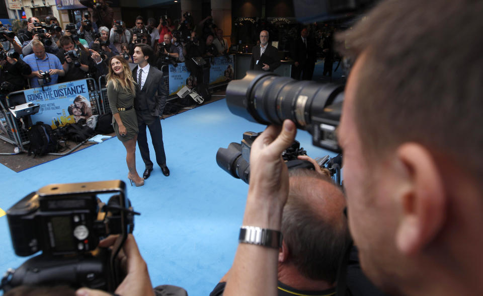 Actors Drew Barrymore (L) and Justin Long pose for photographers as they arrive for the UK premiere of their film 'Going the Distance' in London  August 19, 2010.  REUTERS/Eddie Keogh (BRITAIN - Tags: ENTERTAINMENT)