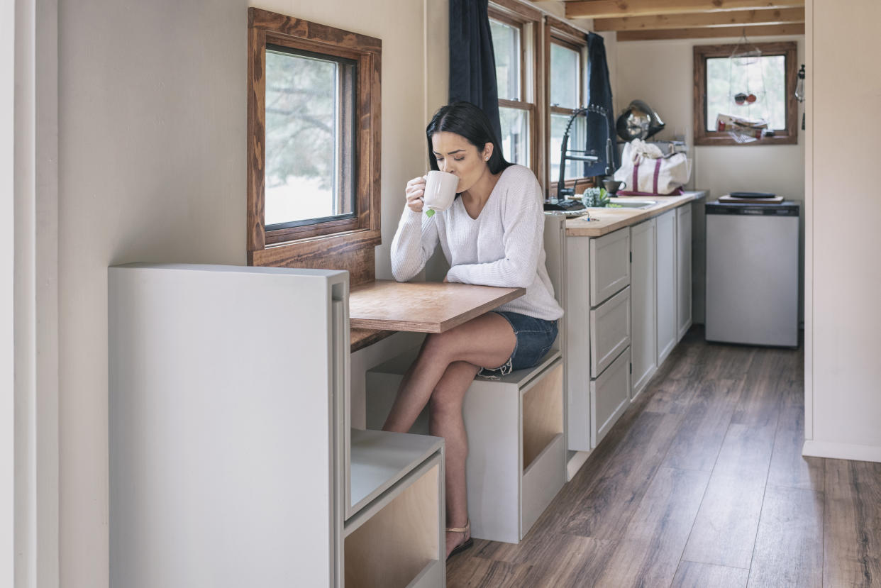 Young woman having tea in her tiny house