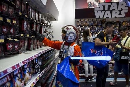 A fan dressed up as Luke Skywalker picks new toys from the upcoming film "Star Wars: The Force Awakens" on "Force Friday" after the launch of the film's new toys in Hong Kong, China, September 4, 2015. REUTERS/Tyrone Siu/Files