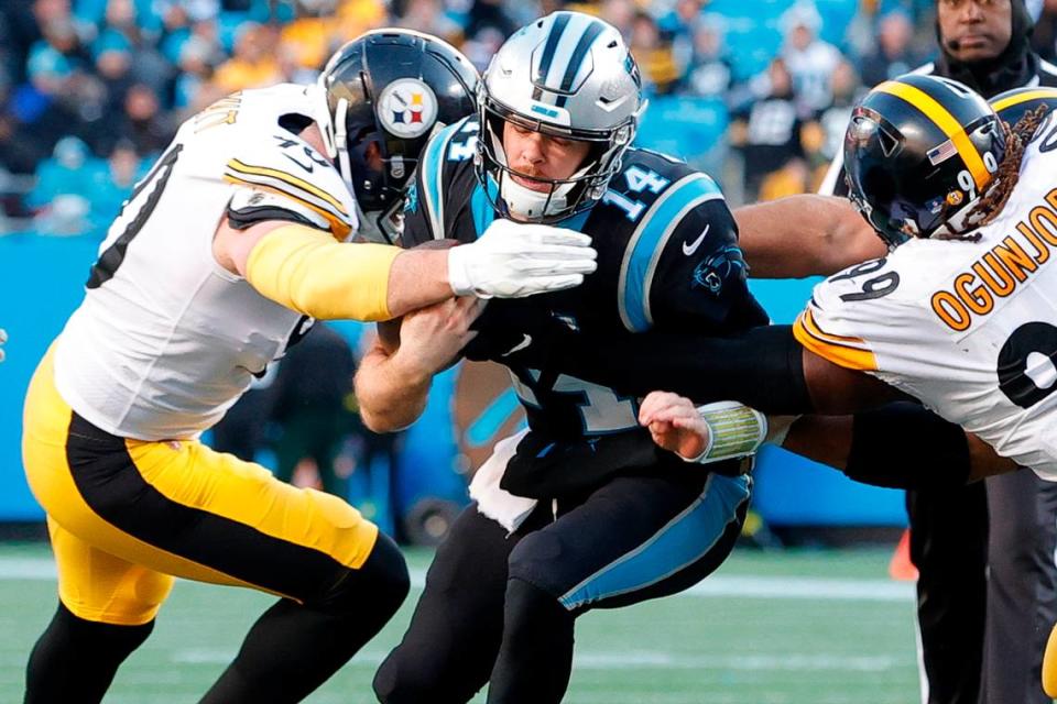 Carolina Panthers quarterback Sam Darnold (14) is stopped by Pittsburgh Steelers linebacker T.J. Watt (90) and Pittsburgh Steelers defensive tackle Larry Ogunjobi (99) during a game at Bank of America Stadium in Charlotte, N.C., Sunday, Dec. 18, 2022.