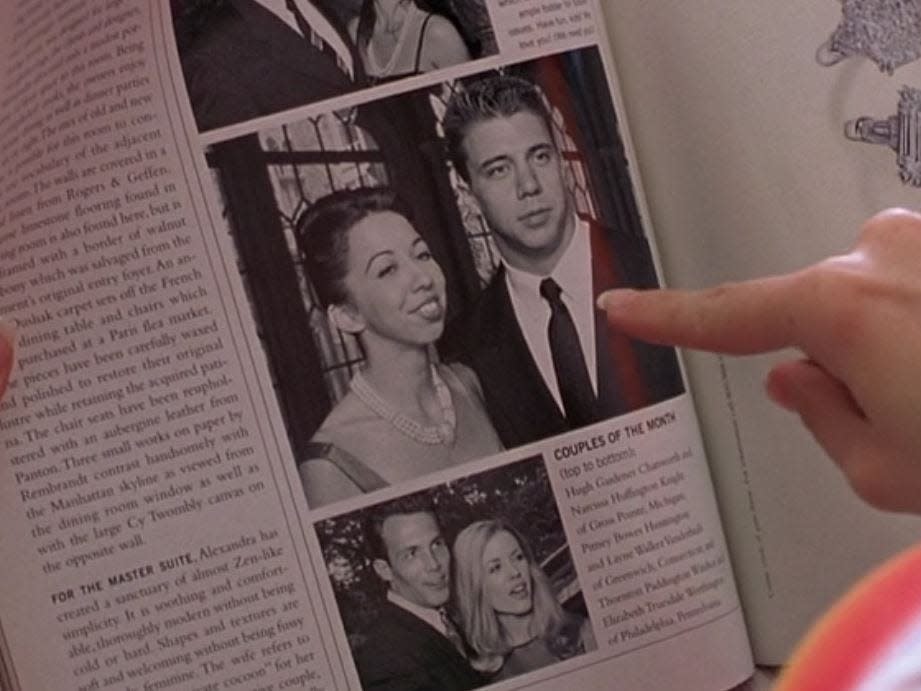 elle's finger pointing at a photo of warren's brother and his new fiance on a page in a magazine