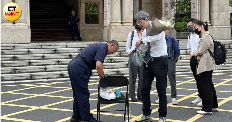 李岳法官手捧白色玫瑰花，準備離開司法院，一旁還有到場關心的司法界人士。（圖／項程鎮攝）