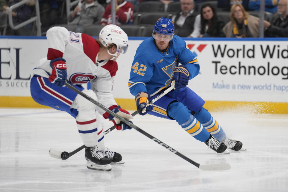 St. Louis Blues' Kasperi Kapanen (42) handles the puck as Montreal Canadiens' Kaiden Guhle (21) defends during the second period of an NHL hockey game Saturday, Nov. 4, 2023, in St. Louis. (AP Photo/Jeff Roberson)