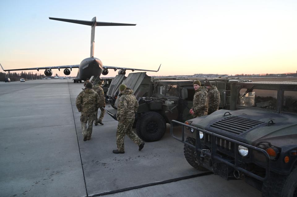 Ukrainian military people at Kyiv airport with tanks and aircraft.