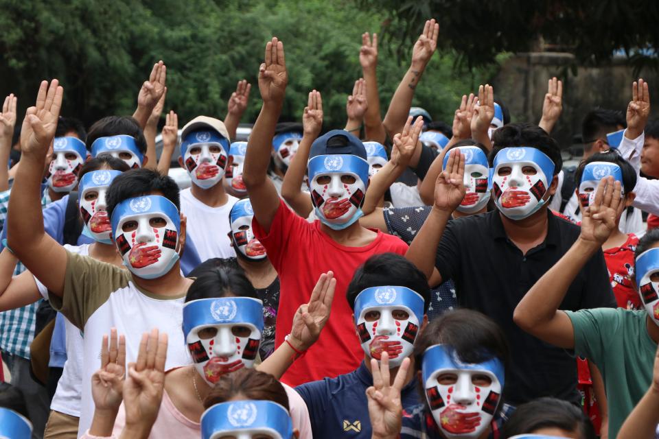 Young demonstrators flash the three-fingered symbol of resistance during an anti-coup mask strike in Yangon, Myanmar, Sunday, April 4, 2021. Threats of lethal violence and arrests of protesters have failed to suppress daily demonstrations across Myanmar demanding the military step down and reinstate the democratically elected government. (AP Photo) ORG XMIT: XVT102