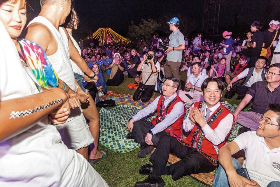 行政院長賴清德（中）到場體驗草地音樂節活動，民眾跳起原住民舞蹈表示歡迎。右為台東縣長黃健庭，左為行政院祕書長卓榮泰。