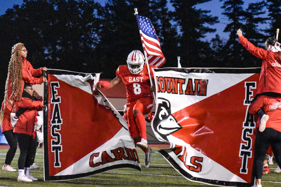 Pocono Mountain East's DJ Kelley breaks through his team banner before East's rivalry game against Pleasant Valley in Swiftwater on Friday, Oct. 1, 2021. Pleasant Valley won, 42-8.