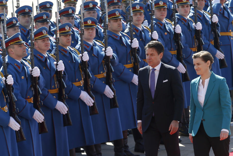 Italian Prime Minister Giuseppe Conte, left, reviews the honor guard during a welcome ceremony ahead of meeting with his Serbian counterpart Ana Brnabic, right, at the Serbia Palace in Belgrade, Serbia, Wednesday, March 6, 2019. Conte is on a one-day official visit to Serbia. (AP Photo/Darko Vojinovic)