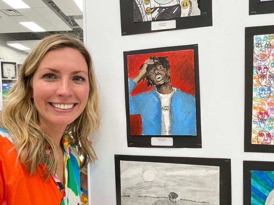 Art teacher Stephanie Beiting shows off a portrait of Playboi Carti the rapper done by eighth-grader Brady Roberts at the annual Fine Arts Night held at Hardin Valley Middle School Tuesday, April 12, 2022.