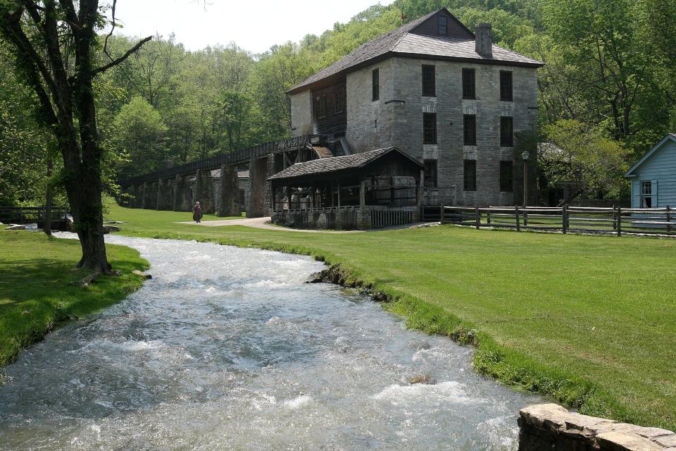 The stream flowing through the Spring Mill's Pioneer Village resembles a miniature whitewater rapids after a heavy rainfall. The stream can be diverted to the wooden chute, seen at the back of the grist mill, to operate the water wheel that powers the grist mill. The chute, water wheel and inner gears for the mill are currently being renovated.