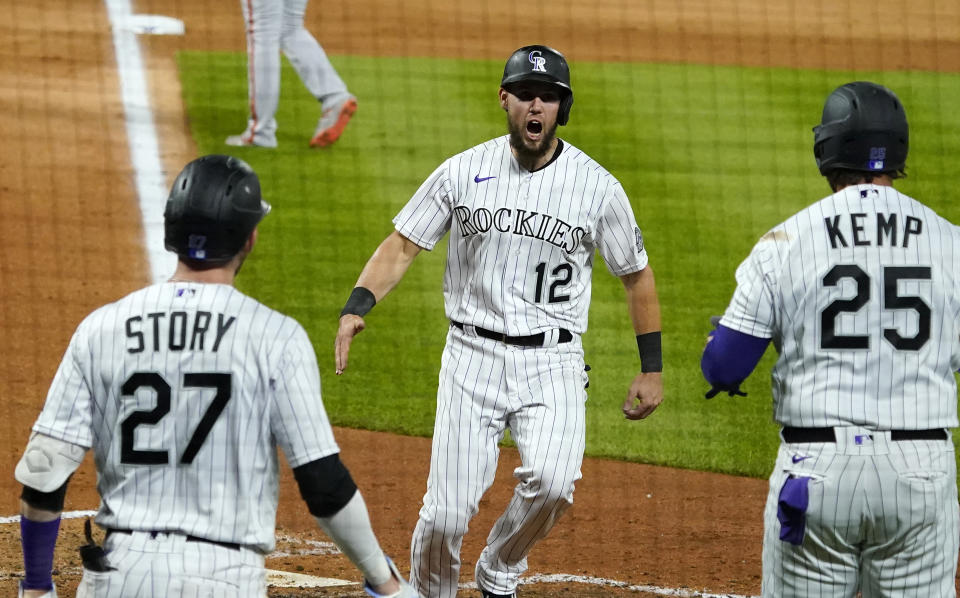 Colorado Rockies' Chris Owings (12) celebrates a run with teammates Trevor Story (27) and Matt Kemp (25) against the San Francisco Giants during the sixth inning of a baseball game, Monday, Aug. 3, 2020, in Denver. (AP Photo/Jack Dempsey)