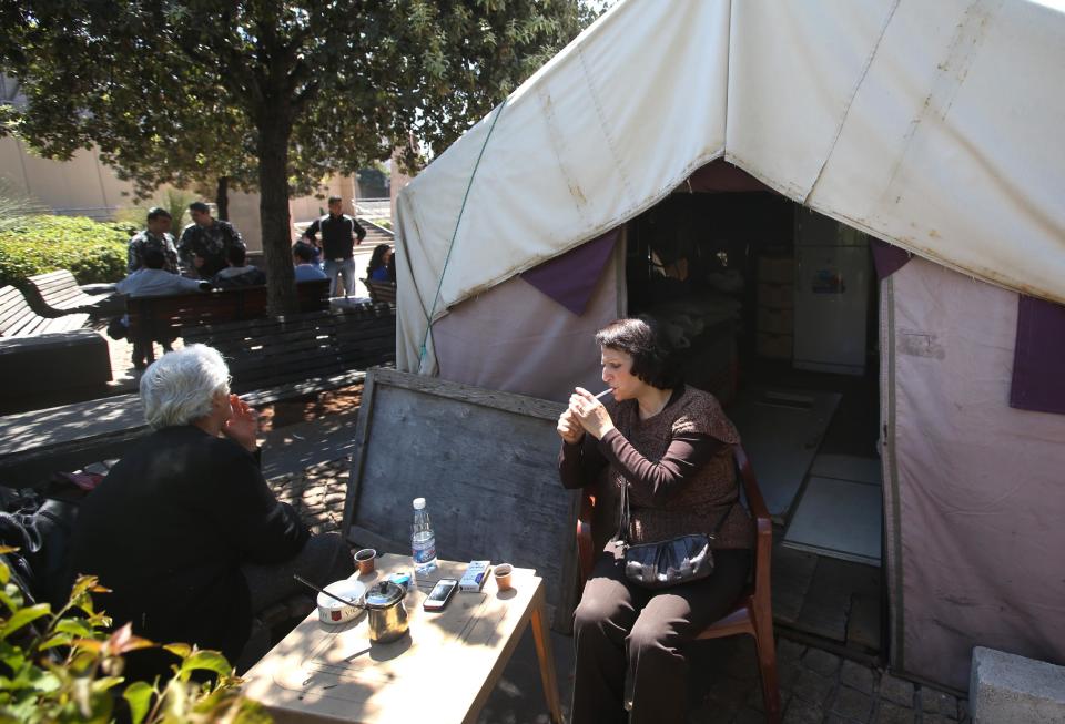 Lebanese Mary Haddad, 67, right, whose son Elie, a Lebanese army soldier, went missing in 1993 sits with Janet Youssef, 48, sister of Milad Youssef who was also a Lebanese army soldier and disappeared in 1983, outside a tent called the "missing tent" which was set up nine years ago for an ongoing sit-in by the relatives of the missing, in front the U.N headquarters, in downtown Beirut, Lebanon, Friday April 11, 2014. Elie and Milad are among an estimated 17,000 Lebanese still missing from the time of Lebanon’s civil war or the years of Syrian domination that followed. Syria’s civil war has added new urgency to the plight of their families, many of whom are convinced their loved ones are still alive and held in Syrian prisons, at risk of being lost or killed in the country’s mayhem. (AP Photo/Hussein Malla)