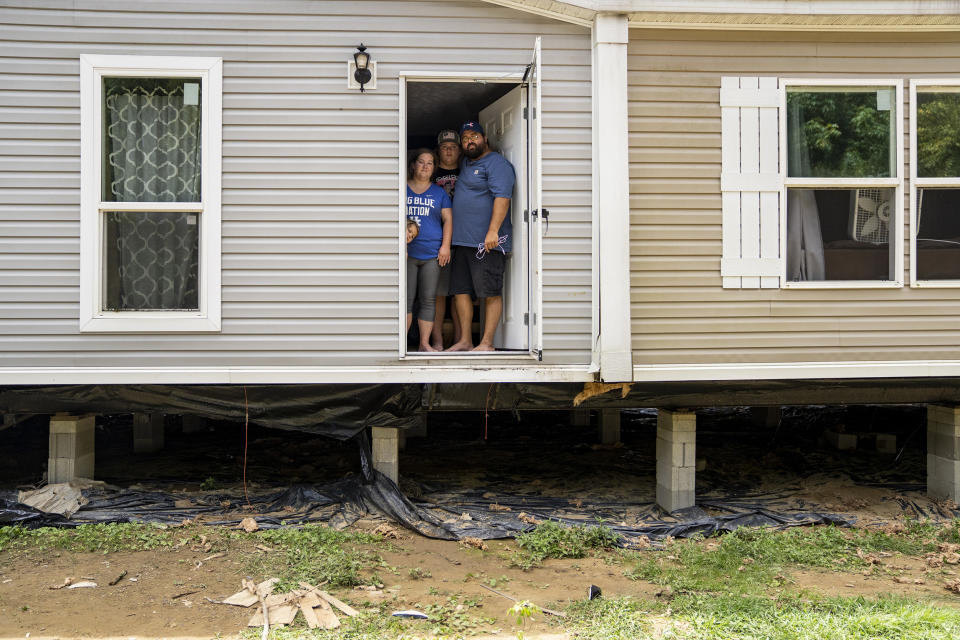 Image: Natasha Skidmore, Gregory Chase Hays, Brelyn Hays and Tatyn Skidmore  in the front door of their house in the Upper River Caney community of Lost Creek, Ky., on Aug. 18, 2022. (Michael Swensen for NBC News)