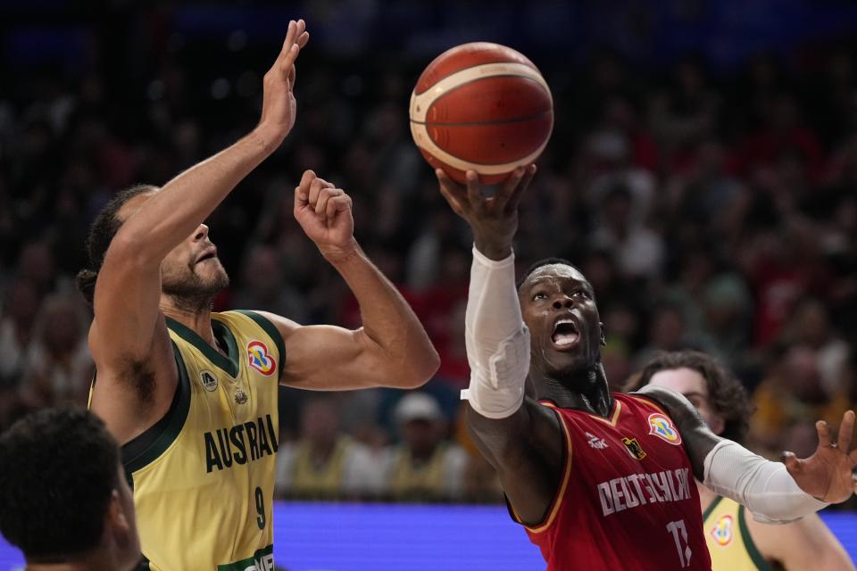 Germany guard Dennis Schroder (17) tries to shoot against Australia forward Xavier Cooks (9) in the second half of the Basketball World Cup group match in Okinawa, southern Japan, Sunday, Aug. 27, 2023. (AP Photo/Hiro Komae)