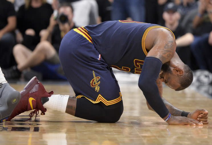 LeBron James takes to the floor after getting an elbow. (AP)