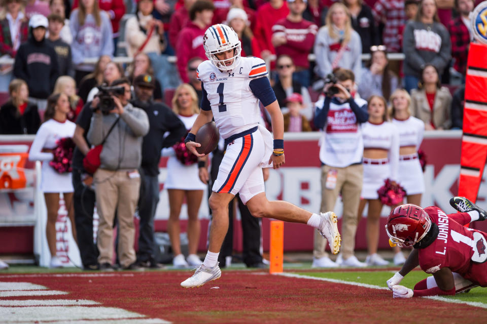 Nov 11, 2023; Fayetteville, Arkansas, USA; Auburn Tigers quarterback Payton Thorne (1) scores a touchdown and looks back at Arkansas Razorbacks defensive back Lorando Johnson (1) during the first quarter at Donald W. Reynolds Razorback Stadium. Mandatory Credit: Brett Rojo-USA TODAY Sports