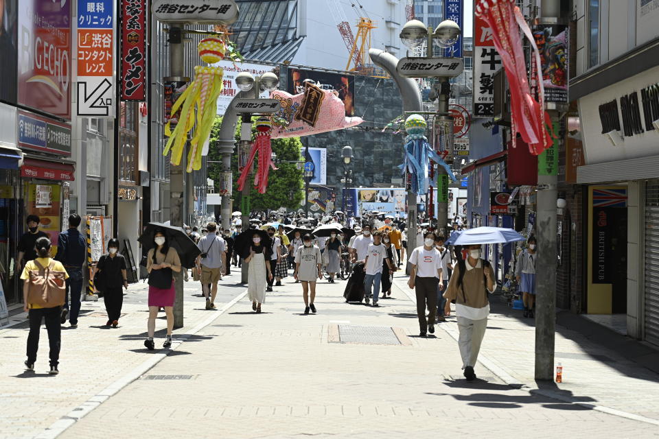 TOKYO, JAPAN - JULY 31: People walking in the street wear a protective mask as a precaution against the coronavirus (Covid-19) on July 31, 2022 in Tokyo, Japan. Japanese capital is swept by a heat wave whose temperature reaches 38 degrees Celsius and more in certain districts and suburbs close to the city. While Japan is facing a new wave of Covid-19 contamination in recent days, the capital is recording contamination records this week amounting to 40,000 people in just one day, a number never recorded in such a short time in Japan. Following the growing number of infected people in Tokyo, several major events related to the summer season have been canceled or restricted in order to contain the spread of the new omicron strain of Covid-19. (Photo by David Mareuil/Anadolu Agency via Getty Images)